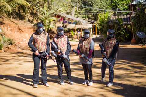 Cuatro jugadores de gotcha con careta en el campo de juego